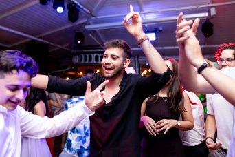 תמונה ובה בחור לבוש חולצה שחורה רוקד ומרים ידיים